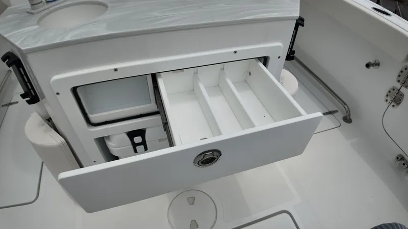 Slide: The Image of Open storage compartment with a drawer on a boat, surrounded by white interior. - 16