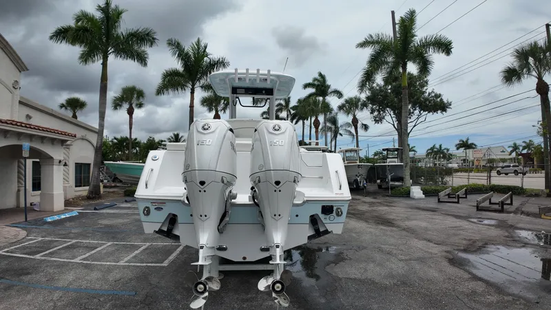 Slide: The Image of A Sea Hunt Ultra 265 SE boat with twin outboard engines is parked, surrounded by palm trees. - 3
