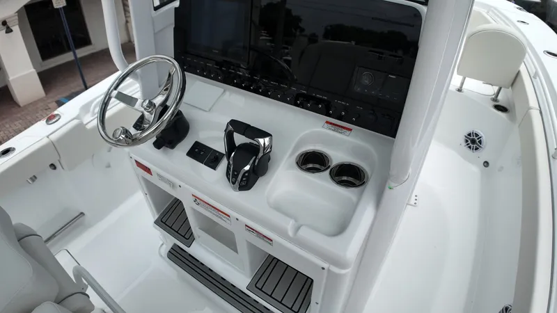 Slide: The Image of The image shows the cockpit of a Sea Hunt Ultra 265 SE boat with modern controls. - 27
