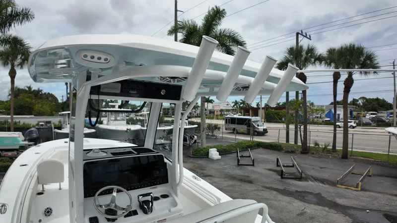 Slide: The Image of The image shows a 2027 Sea Hunt Ultra 265 SE boat with a modern helm and rod holders. - 32