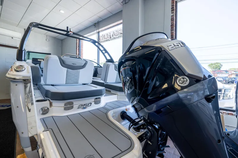 Slide: The Image of 2026 Chaparral 250 OSX boat interior with powerful outboard motor in showroom. - 17