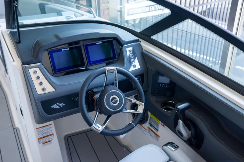 Slide: The Image of 2026 Chaparral 250 OSX boat dashboard with dual Simrad displays and modern steering wheel. - 9
