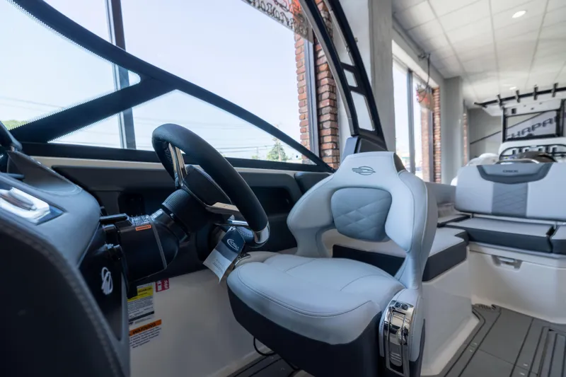 Slide: The Image of Interior view of 2026 Chaparral 250 OSX boat, featuring sleek steering and comfortable seating. - 12