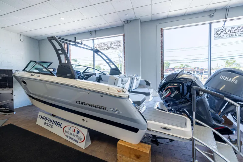 Slide: The Image of 2026 Chaparral 250 OSX boat displayed indoors with Yamaha engines, showcasing sleek design. - 2