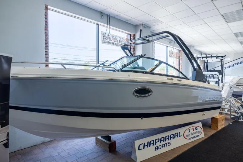 The Image of 2026 Chaparral 250 OSX boat displayed in showroom, featuring sleek design and modern features. - 1