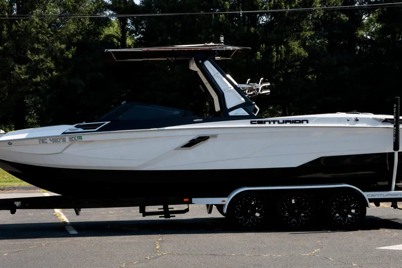 Slide: The Image of 2022 Centurion Ri265 boat on trailer, parked outdoors with trees in background. - 25