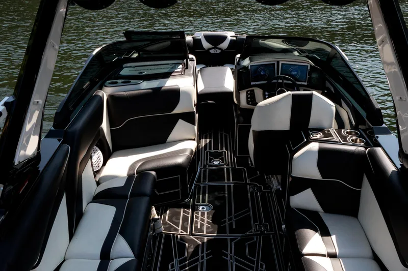 Slide: The Image of 2022 Centurion Ri265 boat interior with black and white seating, sleek design, and modern dashboard. - 14