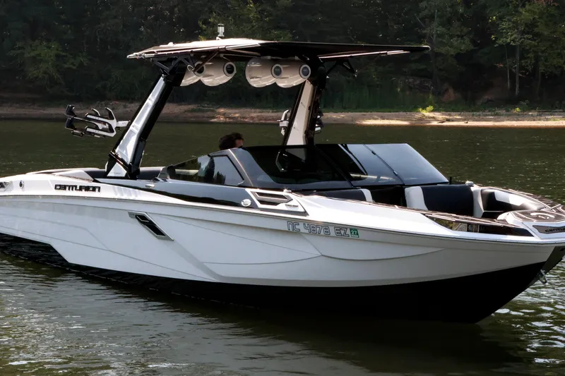 The Image of 2022 Centurion Ri265 boat on a calm lake with lush green shoreline. - 1