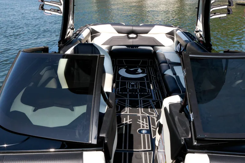 Slide: The Image of 2022 Centurion Ri265 boat interior with sleek black and white seating on the water. - 19
