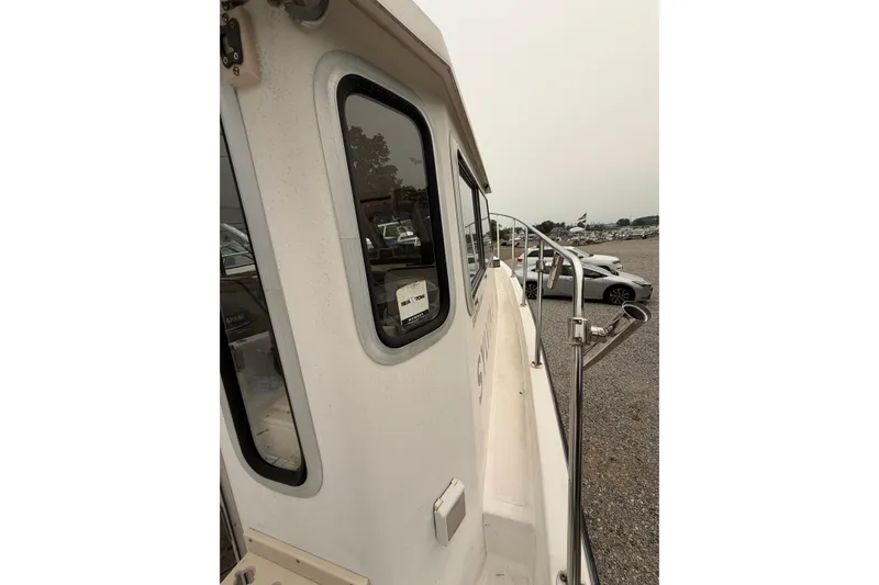 Slide: The Image of Side view of a 2004 Osprey Expedition 26 boat in a parking area. - 16