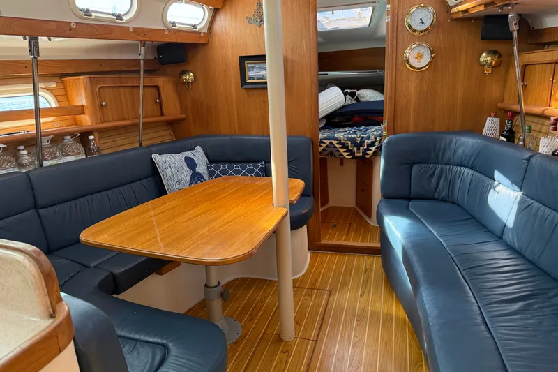 Slide: The Image of Interior of a 2003 Catalina 380 sailboat with blue seating and wooden accents. - 8