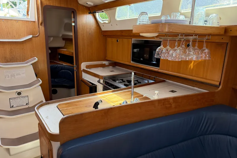 Slide: The Image of Interior of a 2003 Catalina 380 yacht with kitchen and seating area. - 25