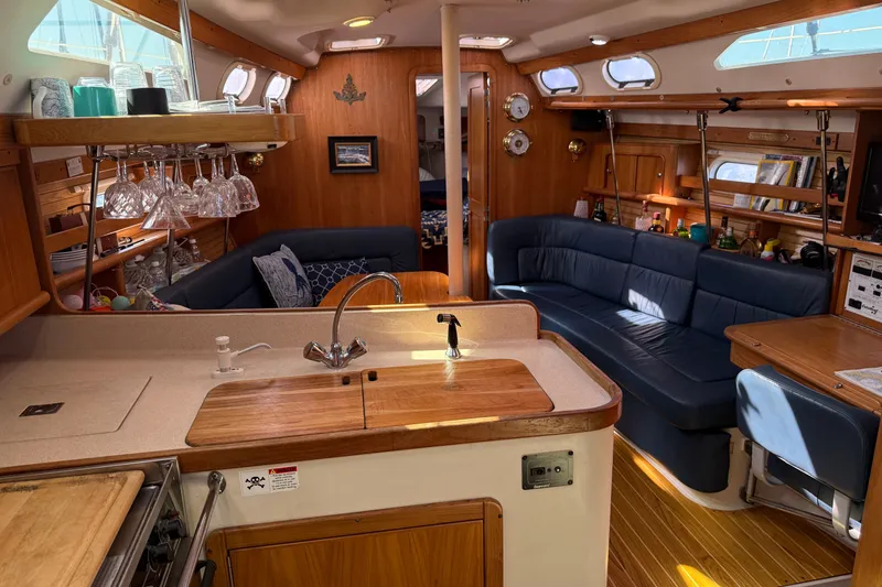 Slide: The Image of Interior of a 2003 Catalina 380 sailboat with cozy seating and a well-equipped kitchen. - 2