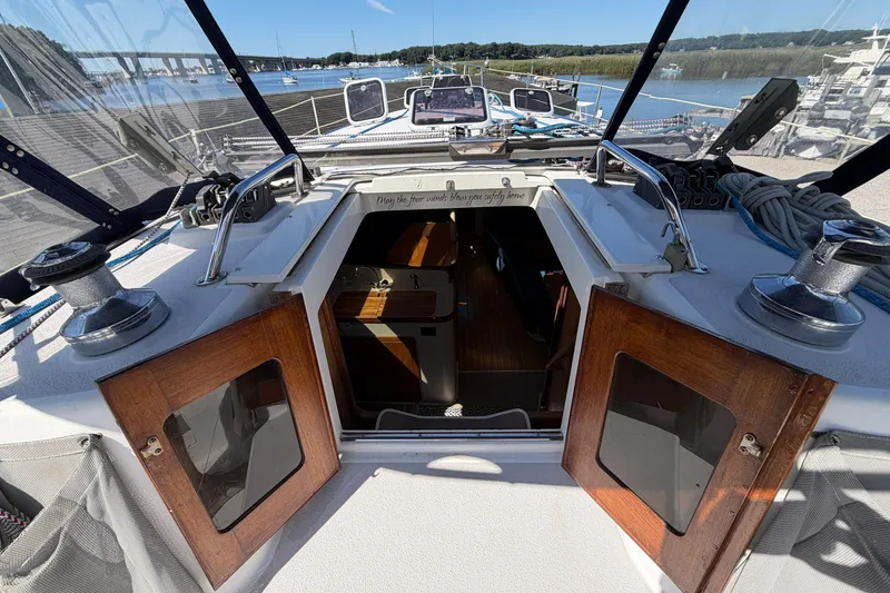 Slide: The Image of Cockpit view of 2003 Catalina 380 sailboat with open cabin doors and marina backdrop. - 6