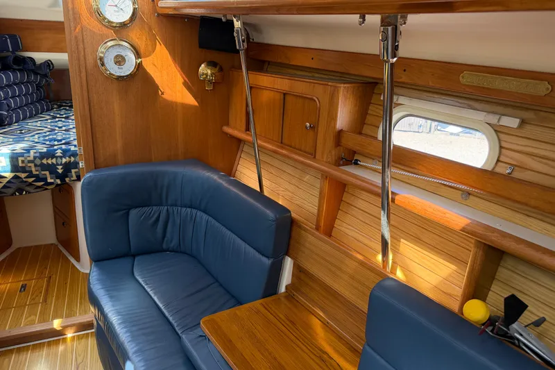 Slide: The Image of Interior of 2003 Catalina 380 sailboat with blue seating and wooden cabinetry. - 18