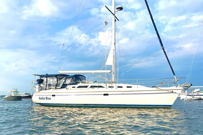 Slide: The Image of Catalina 380 sailboat from 2003 on calm water under a cloudy sky. - 35