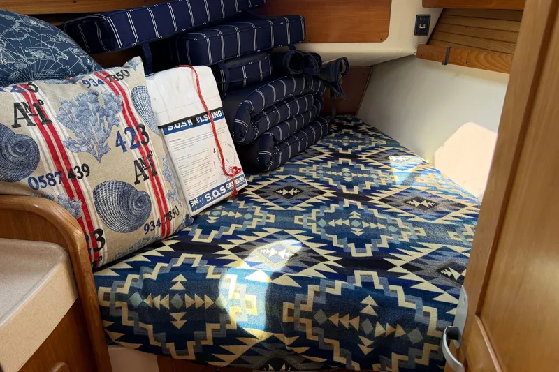 Slide: The Image of Cozy cabin interior of a 2003 Catalina 380 sailboat with patterned cushions and nautical decor. - 19