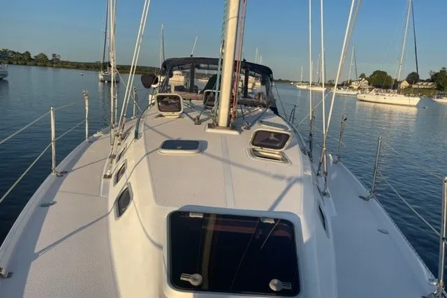 Slide: The Image of 2003 Catalina 380 sailboat on calm water, showcasing deck and rigging. - 32