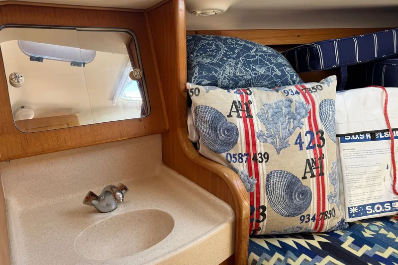 Slide: The Image of Interior of a 2003 Catalina 380 sailboat with nautical-themed decor and compact sink. - 20