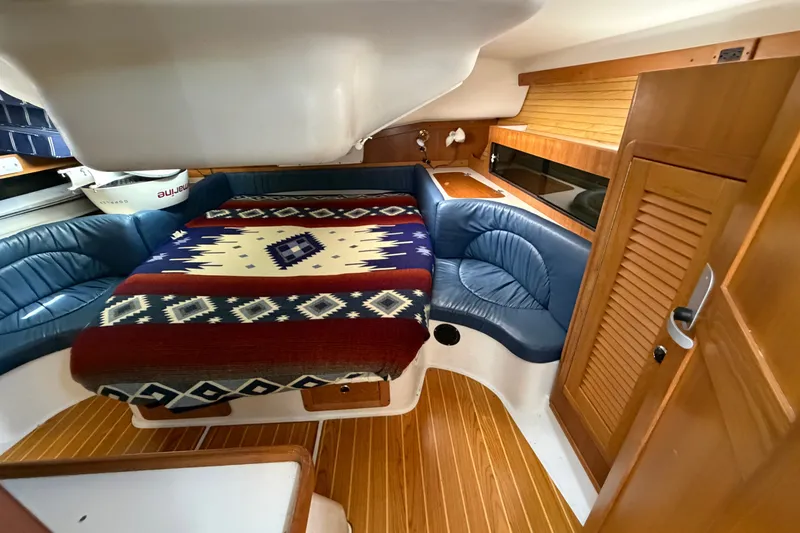 Slide: The Image of Interior of 2003 Catalina 380 sailboat with cozy seating and patterned blanket. - 14