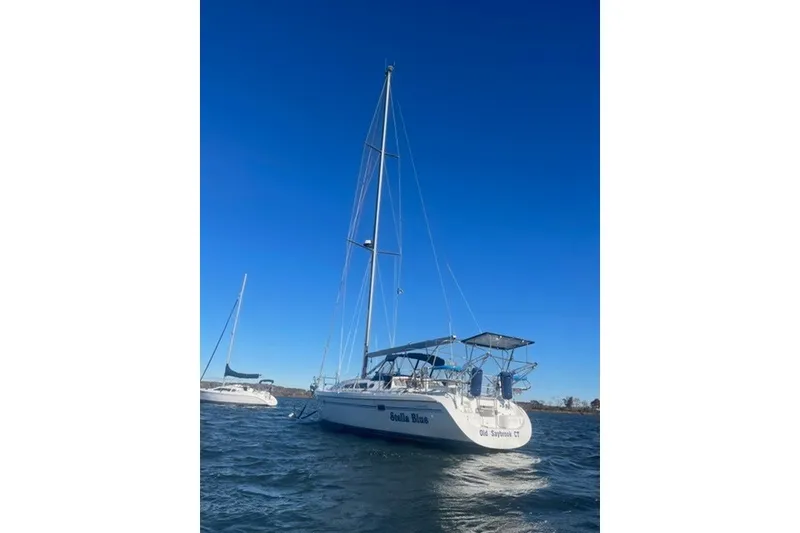 Slide: The Image of 2003 Catalina 380 sailboat on open water under clear blue sky. - 34