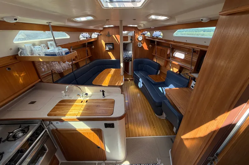 Slide: The Image of Interior of a 2003 Catalina 380 sailboat with wood finishes and blue seating. - 7