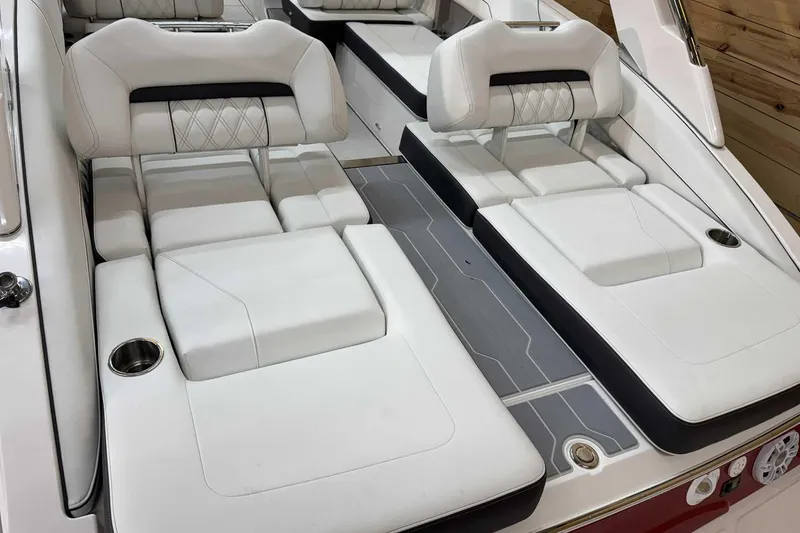 Slide: The Image of Luxurious 2025 Regal LS6 boat interior with white cushioned seating and cup holders. - 6
