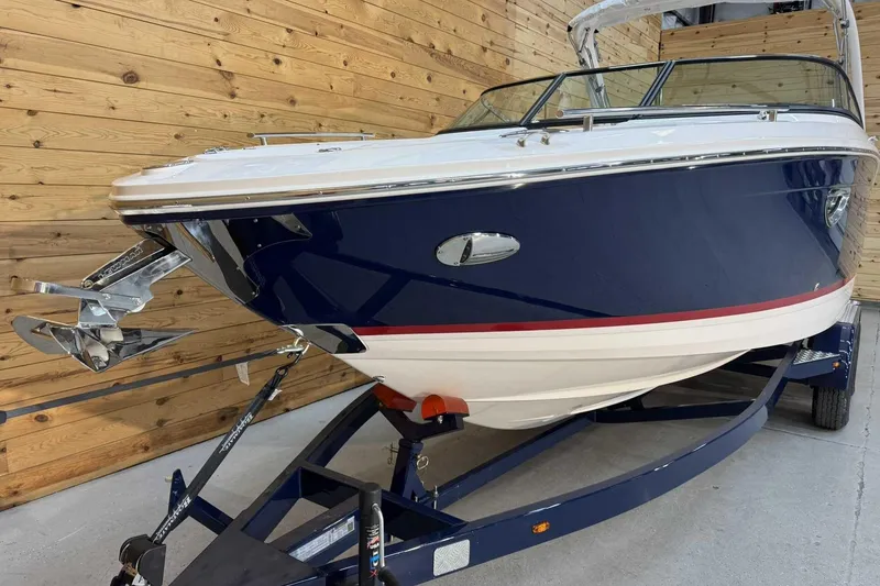 Slide: The Image of 2025 Regal LS6 boat with sleek blue and white design on a trailer. - 4