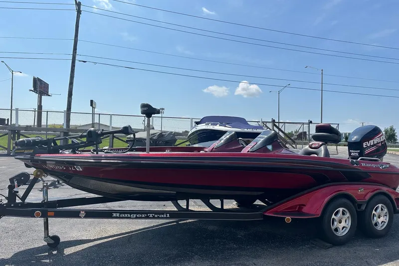 The Image of 2006 Ranger Z20 Comanche bass boat on trailer, featuring Evinrude motor, parked outdoors. - 0