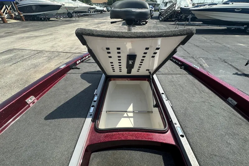 Slide: The Image of 2006 Ranger Z20 Comanche boat with open storage compartment, docked among other boats. - 15