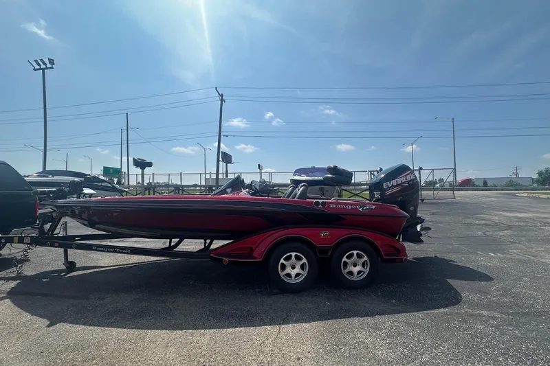 Slide: The Image of 2006 Ranger Z20 Comanche boat with Evinrude motor on trailer under clear sky. - 2