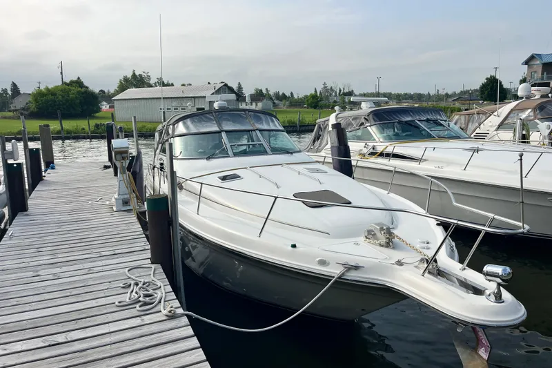 Slide: The Image of 1995 Sea Ray Sundancer 330 docked at a marina, showcasing sleek design and spacious deck. - 2