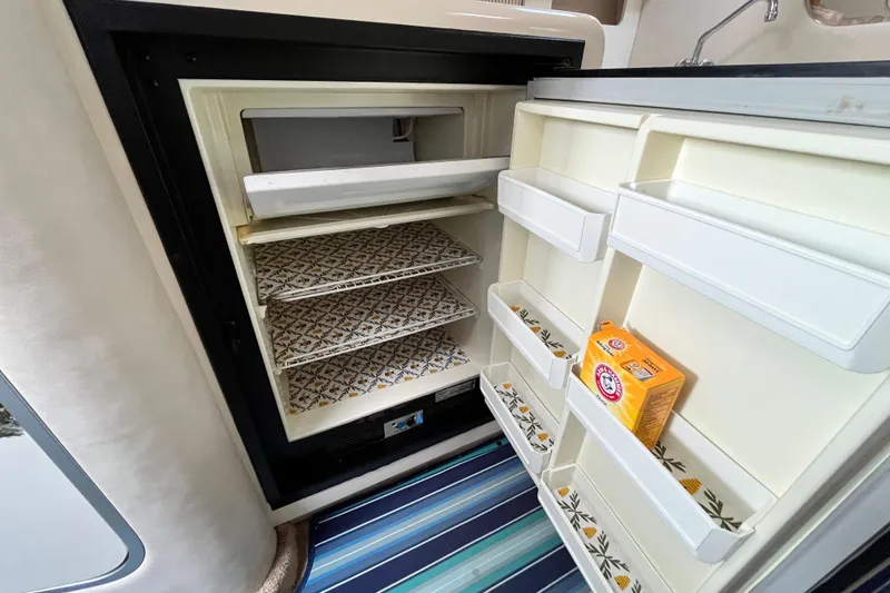 Slide: The Image of Open refrigerator in 1995 Sea Ray Sundancer 330 yacht, featuring organized shelves and baking soda box. - 20