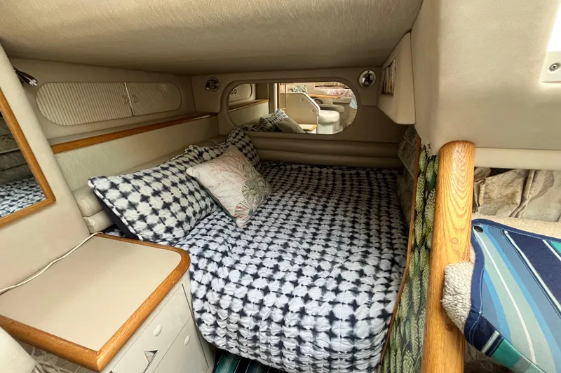 Slide: The Image of Cozy cabin interior of a 1995 Sea Ray Sundancer 330 with patterned bedding and wood accents. - 16