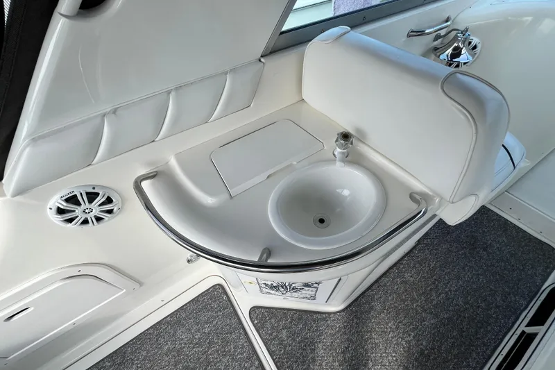 Slide: The Image of 1995 Sea Ray Sundancer 330 interior with sink and speaker, featuring white upholstery. - 12