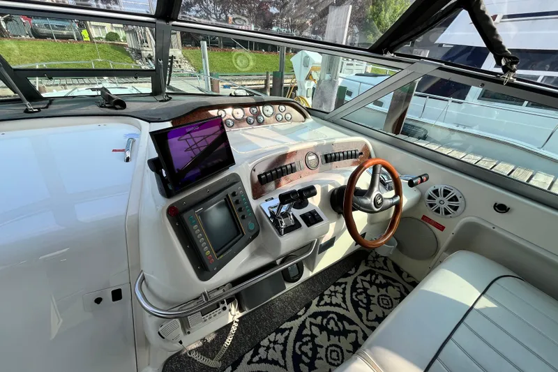 Slide: The Image of Cockpit of a 1995 Sea Ray Sundancer 330 with modern navigation equipment and wooden steering wheel. - 6