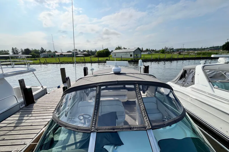Slide: The Image of 1995 Sea Ray Sundancer 330 docked at a marina, showcasing its sleek design and covered cockpit. - 4