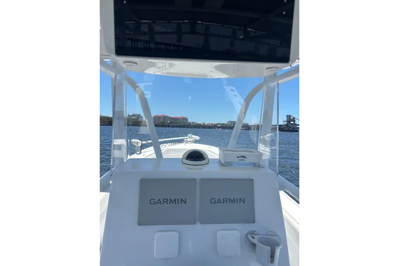 Slide: The Image of 1995 Intrepid 323 Open boat dashboard with Garmin navigation, overlooking calm waters. - 5