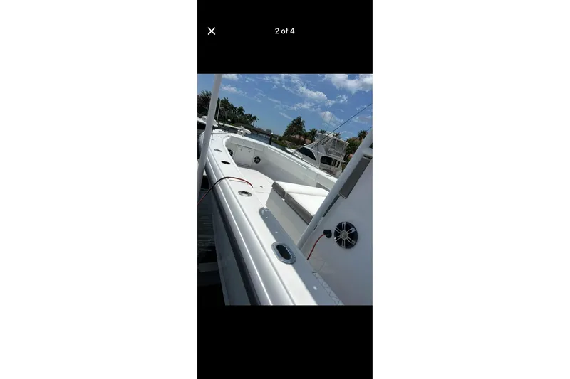 Slide: The Image of 1995 Intrepid 323 Open boat deck with seating, docked under a clear blue sky. - 7