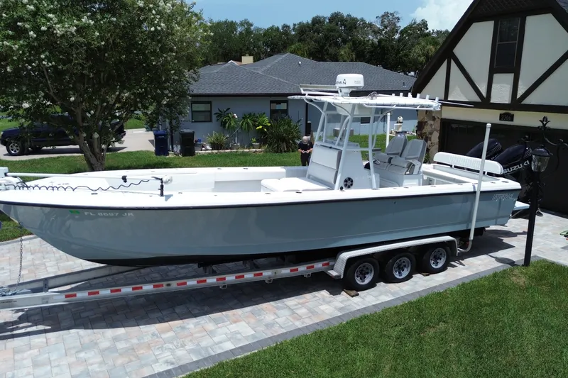 Slide: The Image of 1995 Intrepid 323 Open boat on trailer in residential driveway, surrounded by greenery. - 4