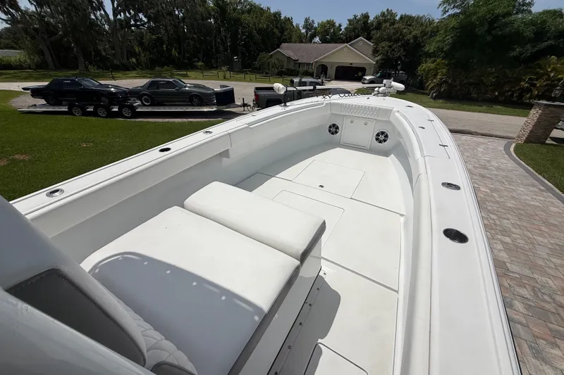 Slide: The Image of 1995 Intrepid 323 Open boat with spacious deck, parked near a house and cars. - 29