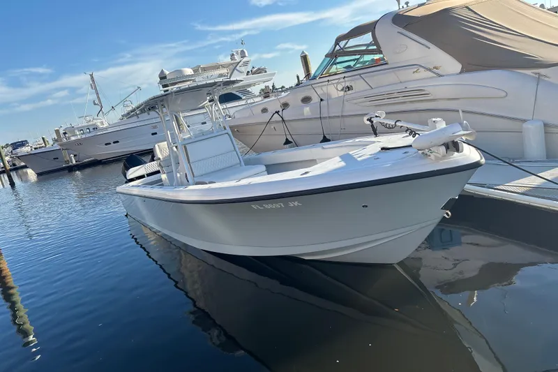 Slide: The Image of 1995 Intrepid 323 Open boat docked in marina, surrounded by luxury yachts. - 2