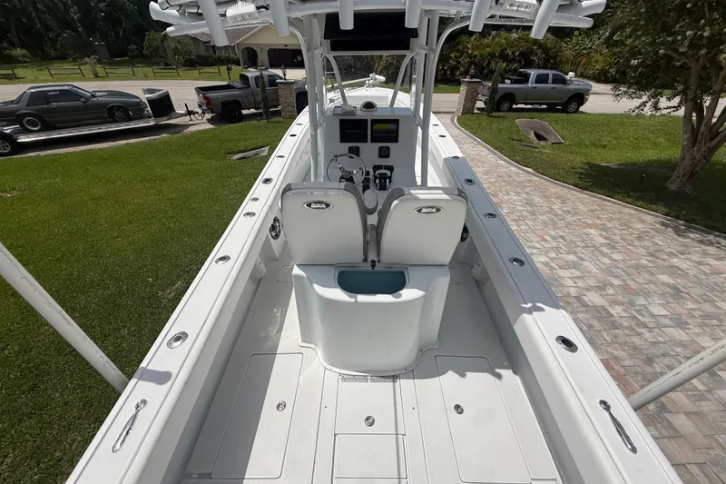 Slide: The Image of 1995 Intrepid 323 Open boat interior with helm, seating, and spacious deck in a driveway setting. - 11