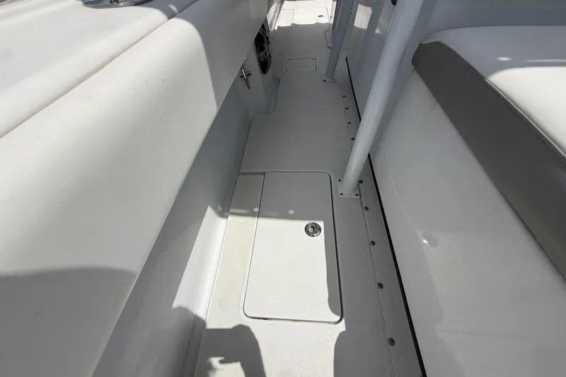 Slide: The Image of Interior view of a 1995 Intrepid 323 Open boat, showcasing sleek white flooring and seating. - 52