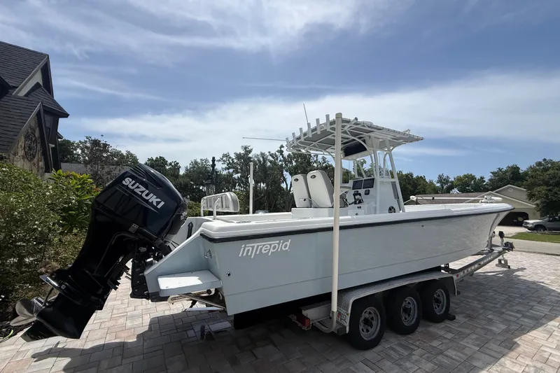 Slide: The Image of 1995 Intrepid 323 Open boat with Suzuki outboard motor on a trailer. - 77