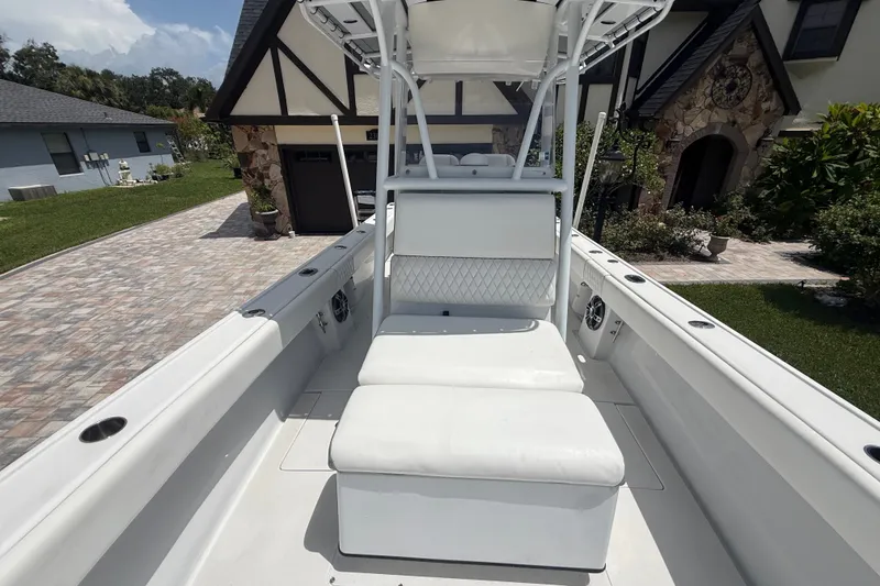 Slide: The Image of 1995 Intrepid 323 Open boat with white seating, parked in a residential driveway. - 49