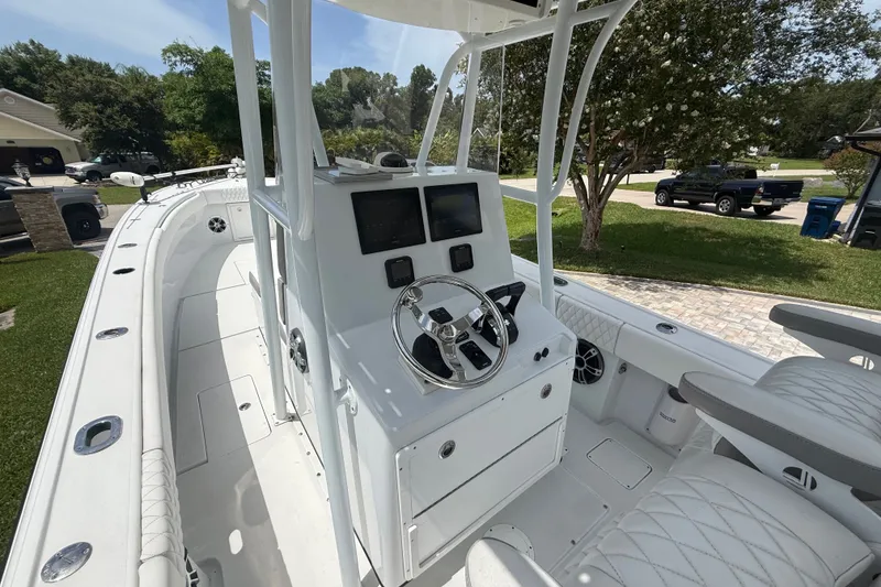 Slide: The Image of 1995 Intrepid 323 Open boat with modern helm, parked in a residential driveway. - 18