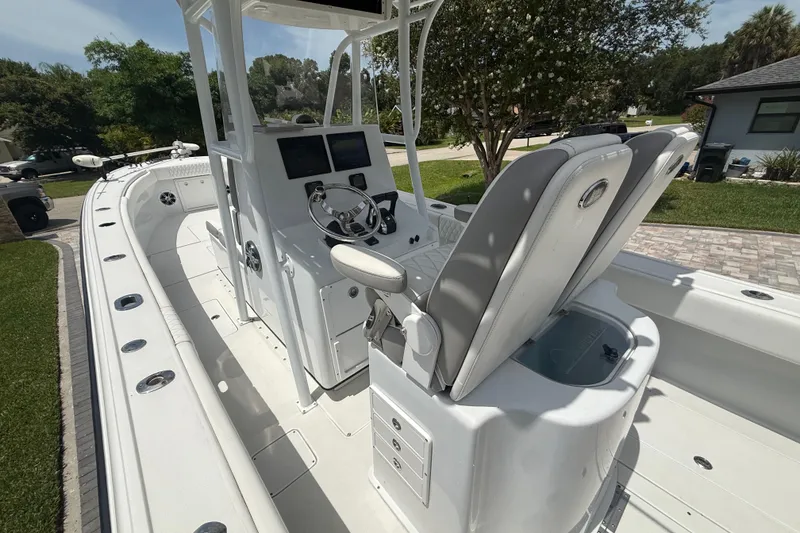 Slide: The Image of 1995 Intrepid 323 Open boat with dual seats and modern dashboard, parked outdoors. - 13