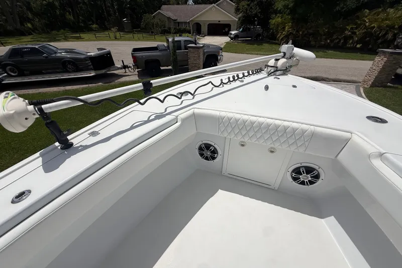Slide: The Image of 1995 Intrepid 323 Open boat with white interior and mounted equipment, parked in a driveway. - 42