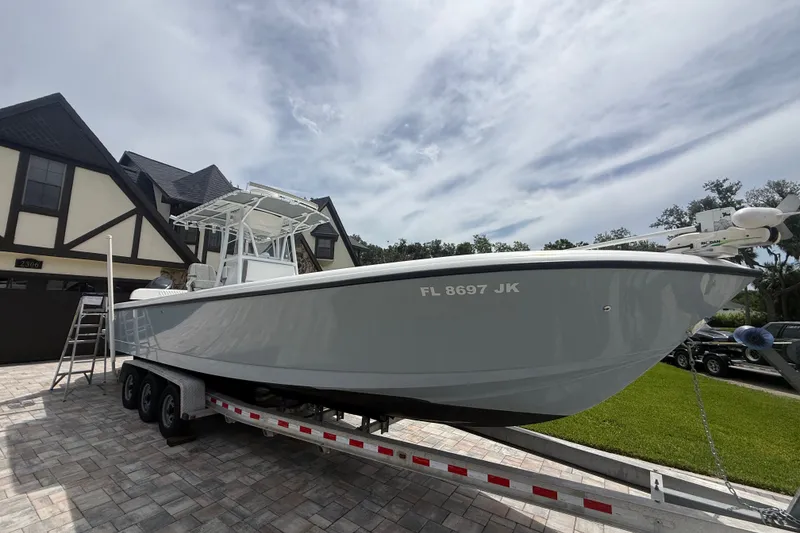 Slide: The Image of 1995 Intrepid 323 Open boat on trailer, parked in front of a house. - 75